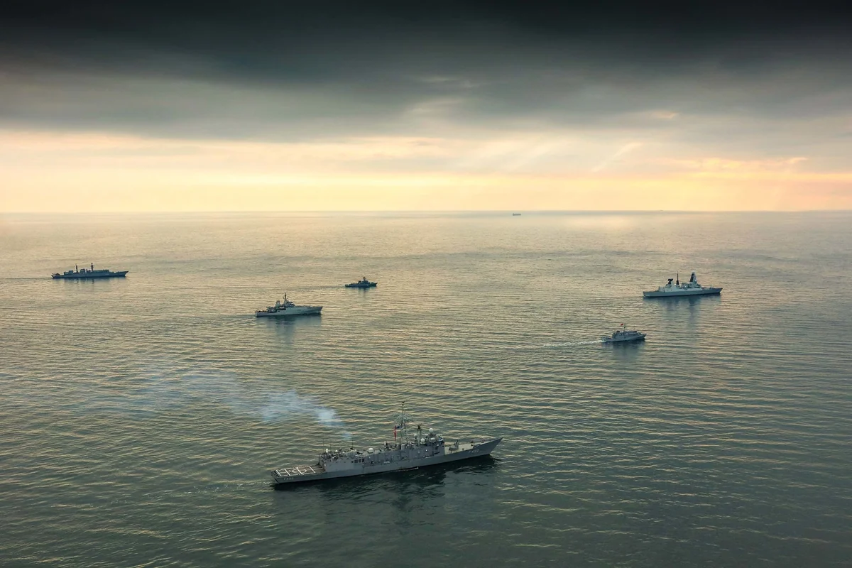 Six warships from Standing NATO Maritime Group Two and mine countermeasures group sailing in formation on a calm Black Sea