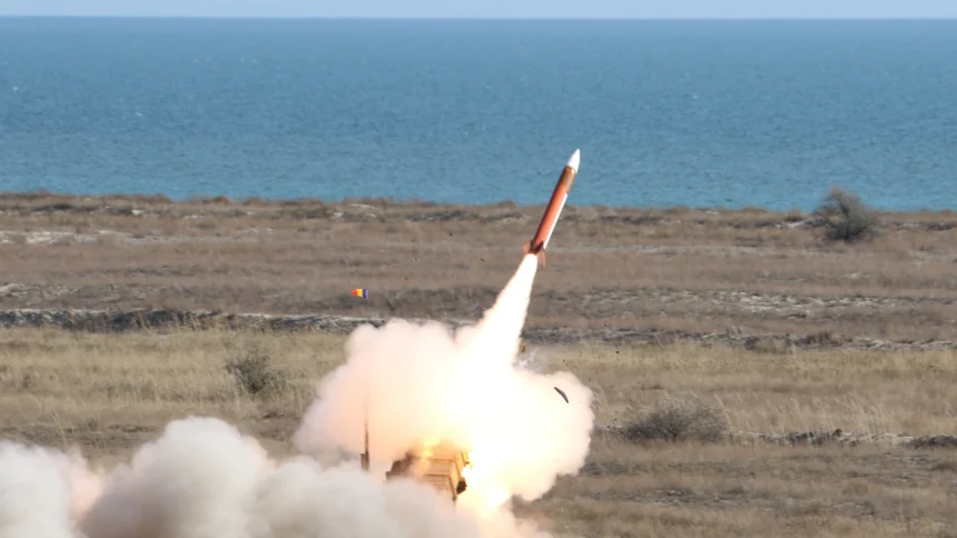 A Patriot interceptor climbs away from its launcher in a cloud of white smoke on a coastal firing range