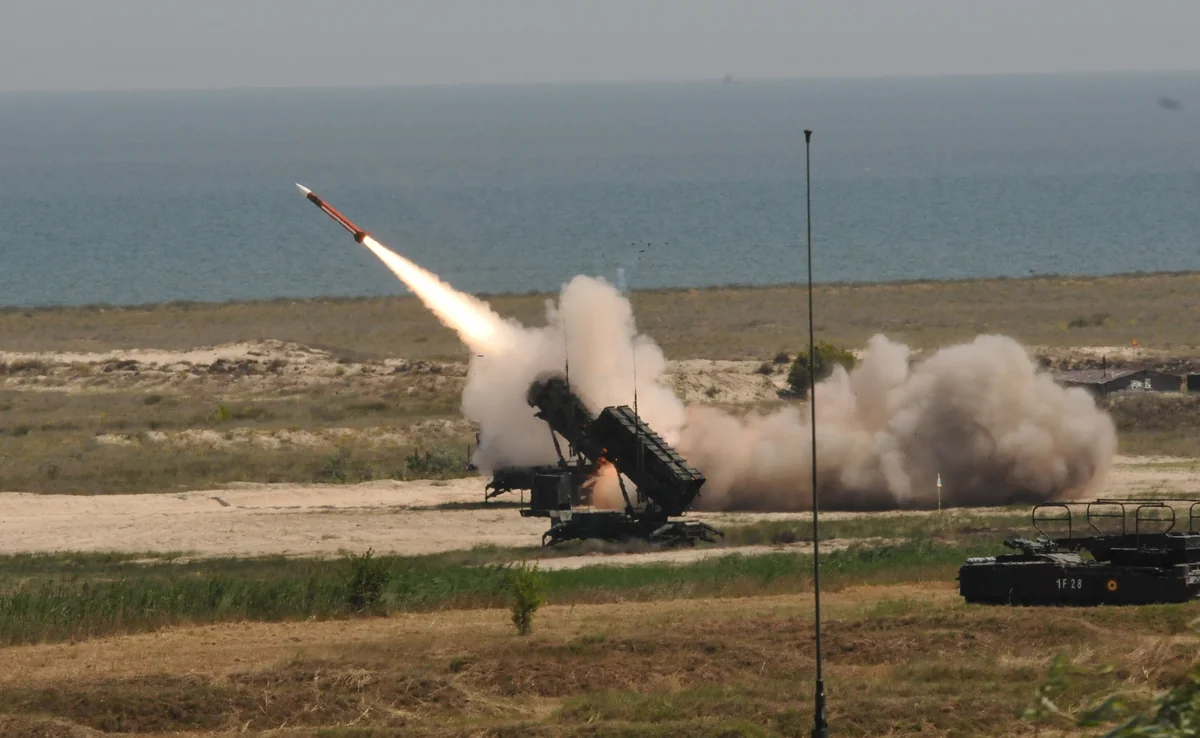 Patriot missile fired from a launcher on a coastal range, with a second launcher in the foreground