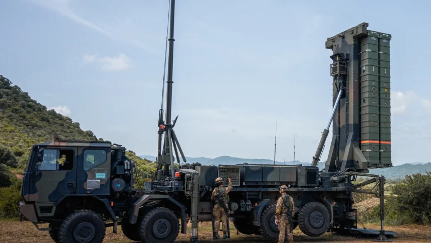 Italian Army SAMP/T missile launcher raised upright on a truck, with two soldiers beside it on a Sardinian hillside